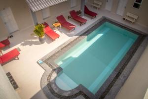una vista aérea de una piscina con sillas y mesas rojas en Mui Ne Hills Budget Hotel, en Mui Ne