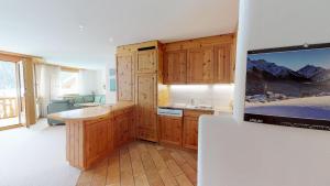a large kitchen with wooden cabinets and a sink at Pizzet A6 in Silvaplana