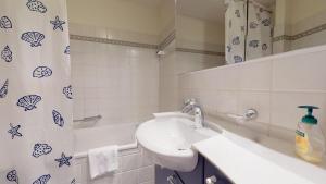 a bathroom with a sink and a shower curtain at Pizzet A6 in Silvaplana +19 photos