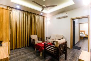 a living room with a couch and chairs and a table at Hotel Manasi Royal in Satara