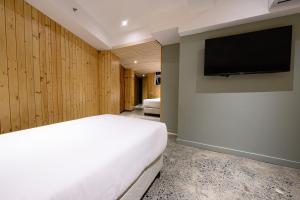 a bedroom with a bed and a flat screen tv at G1 Lodge in Baguio