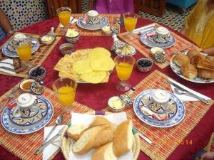 a table topped with plates of bread and orange juice at Riad les jardins Mabrouk in Taroudant