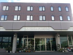 
a large building with a clock on the front of it at Hotel Sunfuraton in Furano
