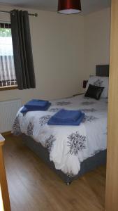 um quarto com uma cama com almofadas azuis em The Cobblers em Inverness