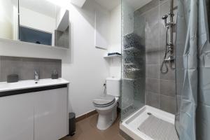 a bathroom with a toilet and a sink and a shower at Le Borie climatisé in Arles
