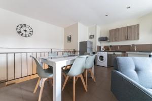 a kitchen and living room with a table and chairs at Le Borie climatisé in Arles +5 photos