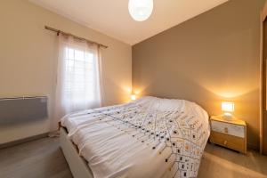 a bedroom with a large bed and a window at Le Borie climatisé in Arles