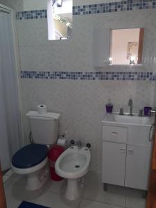 uma casa de banho com um WC branco e um lavatório. em Hotel Casa Jardin em Assunção