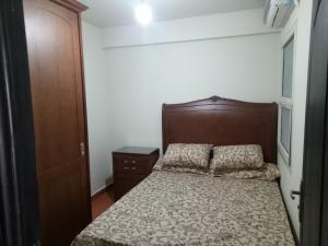 a small bedroom with a bed and a wooden door at one bedroom Chalet at Porto South Beach Royal Sea View Families only in Ain Sokhna