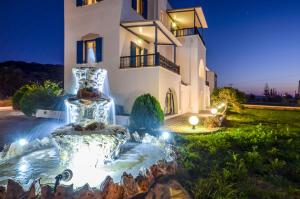 a home with a fountain in front of a building at Gaitani apartments plaka naxos in Mikri Vigla