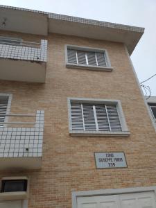 a brick building with windows and a sign on it at Apartamento em Santos in Santos