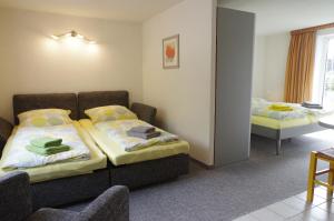 a bedroom with two beds and a table and chairs at Gästehaus Gaens - Ferienwohnung in Schirgiswalde +13 photos