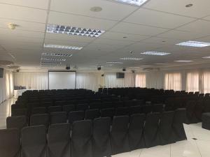 a conference room with black chairs and a screen at Royal Hotel in Polokwane