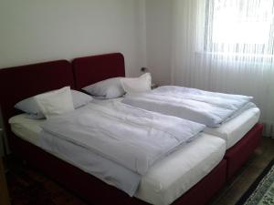 a large bed with white sheets and pillows on it at Seebach Vermietung in Weisendorf