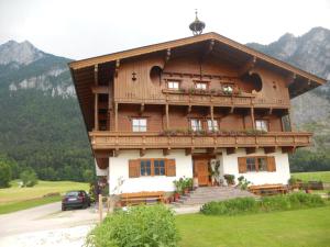 a large wooden house with a porch and a balcony at Neuschwendterhof in Ebbs