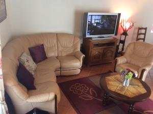 sala de estar con sofá y TV en Au Temps Retrouvé en Courcelles