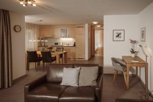 a living room and kitchen with a couch and a table at Haus Mischabel in Zermatt