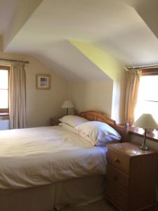 a bedroom with a large bed and two windows at TAN Y GRAIG in Meifod