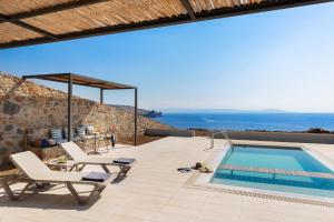 a villa with a swimming pool and a patio at Varkotopi Villas in Agios Pavlos