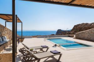 a villa with a pool and a view of the ocean at Varkotopi Villas in Agios Pavlos