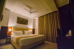Postel nebo postele na pokoji v ubytování Hotel Ten Square, India