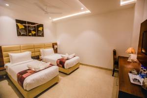 Postel nebo postele na pokoji v ubytování Hotel Ten Square, India