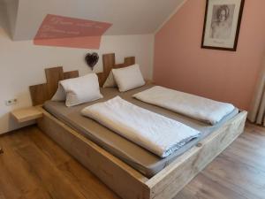 two beds sitting in a room with wooden floors at Gästehaus Auszeit in Unterlamm