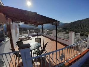 un balcón de una casa con vistas a las montañas en Casa Pino Solo, en Iznájar