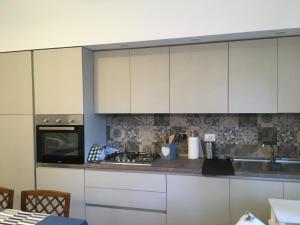a kitchen with white cabinets and a stove at BREZZA MARINA in Rome