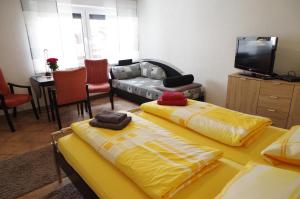 two yellow beds in a living room with a couch at Gästehaus Gaens - Ferienzimmer in Schirgiswalde