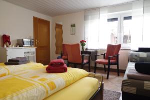1 dormitorio con 2 camas y sillas y cocina en Gästehaus Gaens - Ferienzimmer en Schirgiswalde