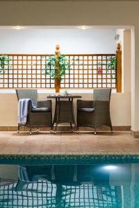 a patio with a table and chairs next to a pool at Beachlands Hotel in Weston-super-Mare