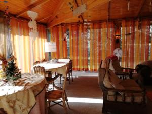 een eetkamer met tafels, stoelen en gordijnen bij Casa da Boavista in Santa Maria da Feira