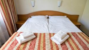 a bed with two towels sitting on top of it at Hotel Kama Park in Sieraków