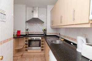 een keuken met een wastafel en een fornuis bij Apartment LORNA in Estepona