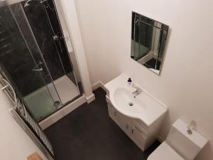 a white bathroom with a sink and a shower at Raeburn in Aberdeen