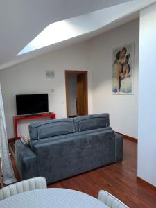 sala de estar con sofá y TV de pantalla plana en Dante Centro, en Rávena