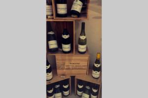 un mucchio di bottiglie di vino su una mensola di le nid de Mymy a Nuits-Saint-Georges