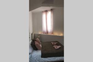 una camera con un letto e due pantofole rosa di le nid de Mymy a Nuits-Saint-Georges