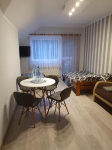 a room with a table and chairs and a bed at Słoneczna Przystań in Kruklanki