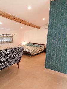 a bedroom with a bed and a couch in a room at le clos du Patre in Caromb