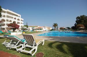 - deux chaises longues installées à côté de la piscine dans l'établissement Apartamento Gomes -Free Airco, wiffi & Swimming Pool- by bedzy, à Porches