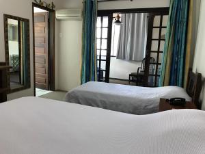a bedroom with two beds and a mirror at Pousada Agua Viva in Abraão