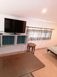 Una sala de estar con un televisor de pantalla plana en una pared. en le clos du Patre, en Caromb