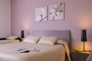 1 dormitorio con 1 cama y 2 cuadros en la pared en Villa Sea Garden - Sicily In, en Pozzallo
