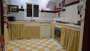 a kitchen with a yellow and white tile floor at Casa Rural la Insula in Santa María de la Alameda