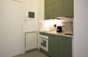 una cucina con armadi verdi e lavandino di Cà de Lerse a Lerici