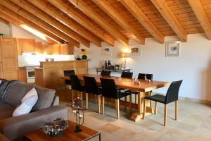 een keuken en eetkamer met een houten tafel en stoelen bij Drive Combles in Bagnes