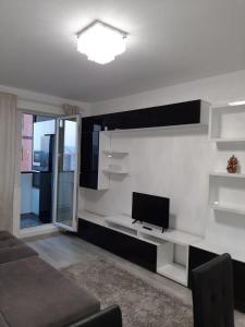 sala de estar con TV en una pared blanca en Luxury Daniel Apartament Residence Militari, en Roşu