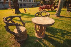 a stone table and bench sitting in a park at Hotel Renar in Fraiburgo